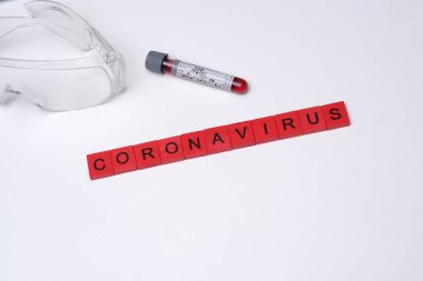 Dünyanın her yerinde Coronavirus var. Scrabble tarafından yazılmış kan örneği ve koronavirüslü resim..