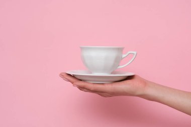 Kahve lütfen. Pembe arka planda bir fincan kahve tutan kadın. Şarj etme zamanı..