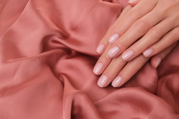 Belas Mãos Femininas Com Delicado Manicure Natural Deitado Cetim Salmão — Fotografia de Stock