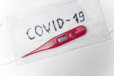 Cerrahi maskenin termometresi. Yüksek sıcaklık virüs enfeksiyonunun ana belirtisidir. Covid 19.