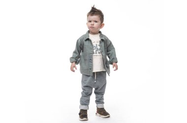 Kafası karışmış küçük çocuk beyaz arka planda duruyor. Kızgın görünüyor..