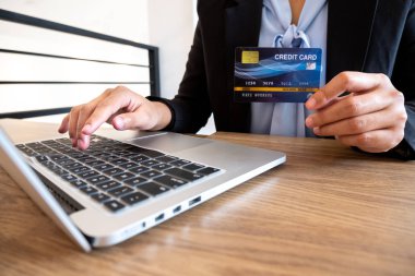 İş kadınları çevrimiçi alışveriş ve ödemeleri İnternet üzerinden yapmak için kredi kartları ve dizüstü bilgisayarlar kullanıyorlar