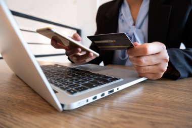 Online alışveriş ve ödeme için iş kadını tüketici Holding kredi kartı ve akıllı telefon Internet üzerinde bir satın alma yapmak