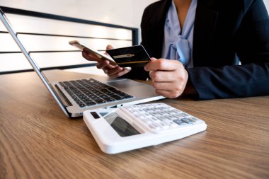 Online alışveriş ve ödeme için iş kadını tüketici Holding kredi kartı ve akıllı telefon Internet üzerinde bir satın alma yapmak