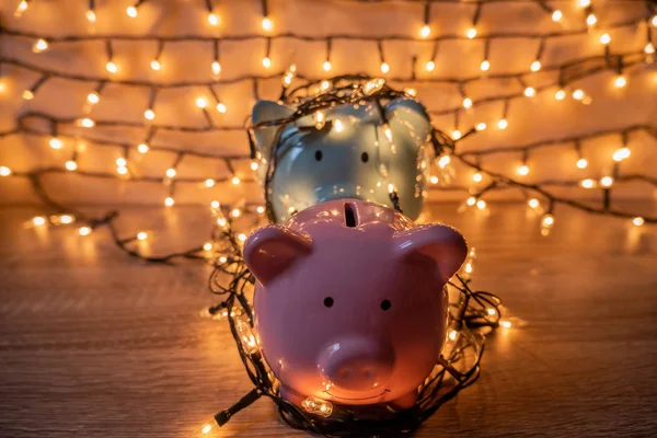 Pink and blue piggy bank with glittering lights, organize parties for successful activities to save money for retirement