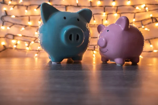 Pink and blue piggy bank with glittering lights, organize parties for successful activities to save money for retirement