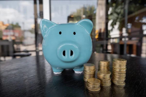 Blue piggy bank with coin pile, step up growing business to success and saving for retirement concept