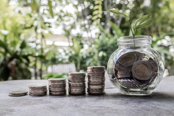 Glass jar piggy bank with coins. Plan your savings, run a growing business for success and save for retirement