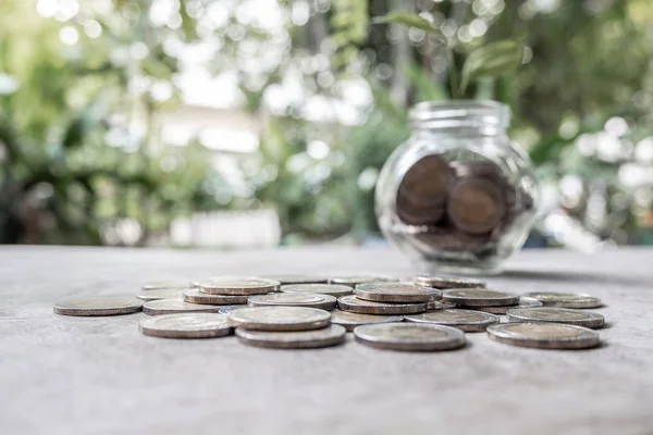 Glass jar piggy bank with coins. Plan your savings, run a growing business for success and save for retirement