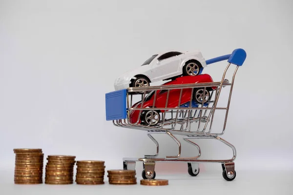 Coche rojo y blanco en carro azul con pila de monedas, ahorrando dinero para comprar coche nuevo y el concepto de seguro — Foto de Stock