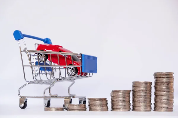 Coche rojo en carro azul con pila de monedas, ahorrando dinero para comprar un coche nuevo y el concepto de seguro — Foto de Stock