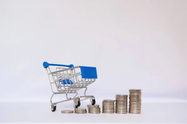 Carrinho azul com pilha de moedas, economizando dinheiro para fazer compras em seu conceito de férias — Fotografia de Stock