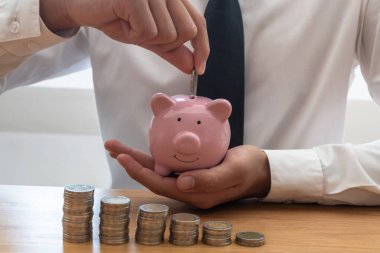Bir kumbarayı elinde tutan ve birikimlerini gösteren bir grafik olarak para yerleştiren iş adamları, başarı için büyüyen bir iş alanı ve emeklilik için tasarruf