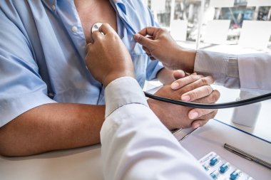 Erkek doktorlar steteskop kullanarak nabız testi yaparlar. Hastanenin sağlık kontrolüne başlayın. Tedavi kavramları ve iyi sağlık