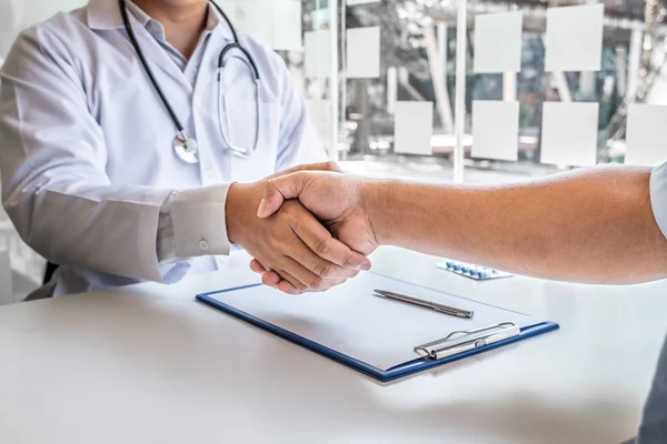 Hasta tedavisini bitirdikten sonra doktorlar ve erkek hastalar el sıkışıyor. Tıbbi kavramlar ve sağlık