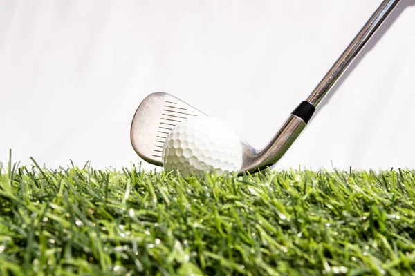 Клуб для гольфа, в котором играют люди, бьющие мячом для гольфа по искусственной траве. Зеленый означает быть готовым к игре в гольф — стоковое фото