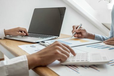 Sonuçları gösteren çizelge ve grafikleri tartışan iki iş lideri büyük başarı için yeni bir strateji başlatmayı planlıyor.