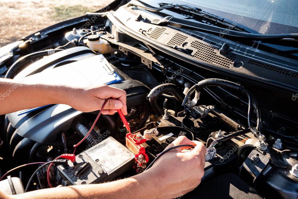 The hands of the repairman are checking the order of the engine using modern tools