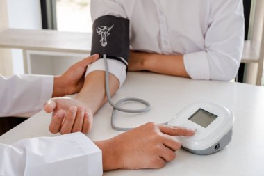 Doktor kan basıncını ölçer, hastalar sağlık kontrolünden geçer ve sağlık hizmetleri hakkında yakından konuşur.