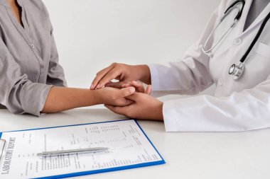 Kadın doktor hastayla el sıkışıyor, kolun üst kısmındaki nabzı inceliyor, hastanede ön sağlık muayenesi yapılıyor. Tedavi kavramları ve iyi sağlık