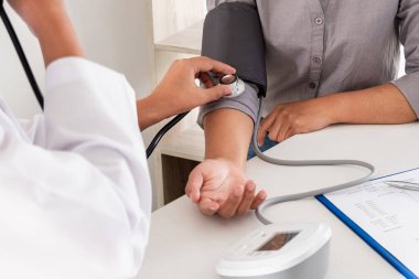 Doktor kan basıncını ölçtü, hasta kalp atışlarını inceledi ve sağlık hizmetlerinden yakından bahsetti.
