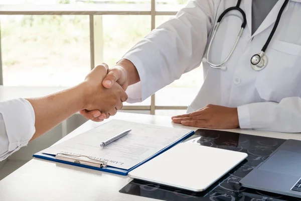 Hasta tedavisini bitirdikten sonra doktorlar ve hastalar el sıkışıyor. Tıbbi kavramlar ve sağlık