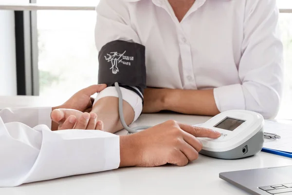 The doctor checks the blood pressure, the patients have an initial health check and talked about health care closely — Stock Photo, Image