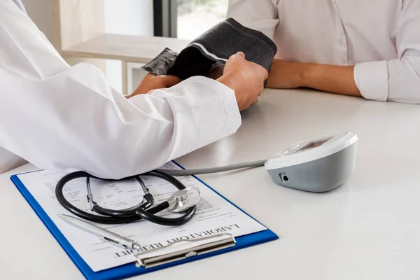 El médico revisa la presión arterial, los pacientes se someten a un control de salud inicial y hablan de la atención médica de cerca. — Foto de Stock