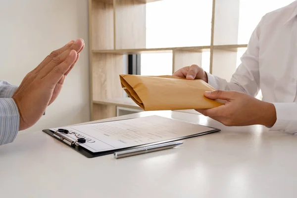 The businessman denies the money in envelope proposed by his partner to bribe the concept of bribery and corruptionr — Stock Photo, Image