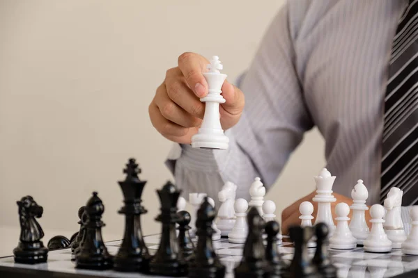 hand of businessman moving chess in competition, shows leadership, followers and business success strategies