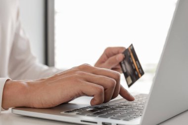 İş adamları online alışveriş için kredi kartları ve dizüstü bilgisayarlar kullanır ve ödemeleri interne yaparlar..