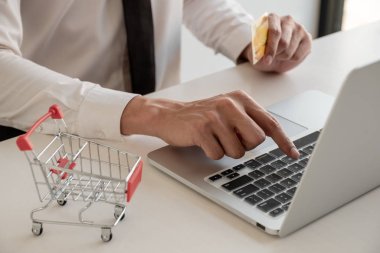 İş adamları online alışveriş için kredi kartları ve dizüstü bilgisayarlar kullanır ve ödemeleri interne yaparlar..