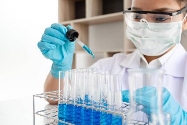 Tıp bilimcileri bir kimya laboratuvarında virüsü analiz etmek için test tüpüne bir örnek pipet yerleştirdiler. Bilimsel araştırma kavramları.