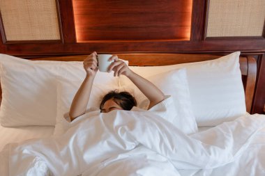 Odada uyandıktan sonra kollarını uzatan genç kadın rahatlatıcı bir duyguyla uyandı..