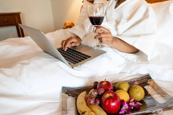 스러운 방에서 맛있는 과일을 먹으며 노트북을 연주하는 여성의 — 스톡 사진