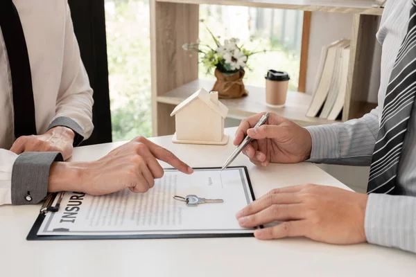 Real estate agent broker with home insurance forms In order for the customer to sign the contract according to the agreement buying home insurance officially Home insurance concept.
