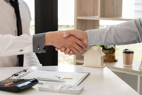 İş adamları ve emlakçılar, ev sigortası ve sözleşme imzalama görüşmelerini tamamladıktan sonra el ele verdiler. Ev sigortası kavramı.