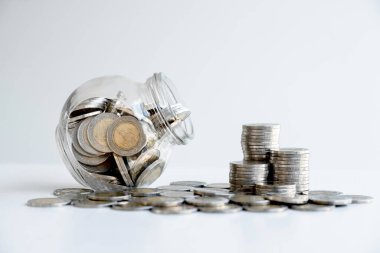 Bozuk paralarla dolu cam kavanoz kumbarası. Birikimlerinizi planlayın, başarı için büyüyen bir iş yapın ve emeklilik için tasarruf edin..