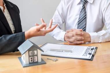 House modelli bir emlakçı ev sigortası almak için müşterilerle konuşuyor. Ev sigortası kavramı.