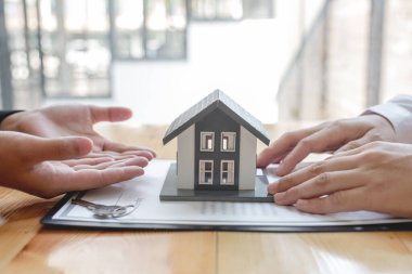 House modelli bir emlakçı ev sigortası almak için müşterilerle konuşuyor. Ev sigortası kavramı.