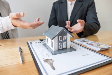 House modelli bir emlakçı ev sigortası almak için müşterilerle konuşuyor. Ev sigortası kavramı.