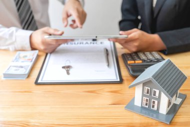 House modelli bir emlakçı ev sigortası almak için müşterilerle konuşuyor. Ev sigortası kavramı.