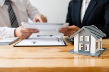House modelli bir emlakçı ev sigortası almak için müşterilerle konuşuyor. Ev sigortası kavramı.