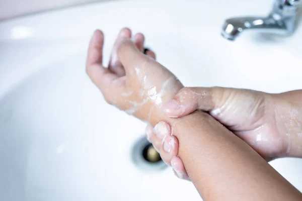 Woman's hands wash their hands with soap, cleanse the hands in the tub with soap, personal hygiene.