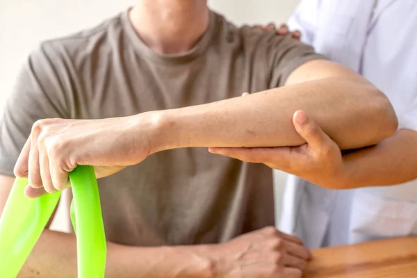 Female Physiotherapists Provide Assistance Male Patients Elbow Injuries Examine Patients — Stock Photo, Image