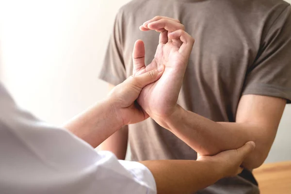 Vrouwelijke Fysiotherapeuten Helpen Mannelijke Patiënten Met Polsverwondingen Een Revalidatiecentrum Fysiotherapeutische — Stockfoto