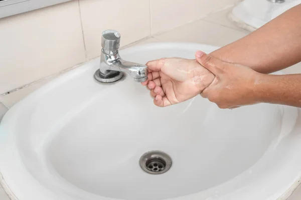 Woman's hands wash their hands with soap cleanse the hands in the tub with soap, personal hygiene.