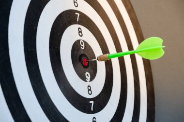 Dart tahtasının ortasındaki ok başarılı bir iş hedefi kavramını gözler önüne seriyor.