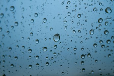 Pencerede yağmur damlaları görünüyor