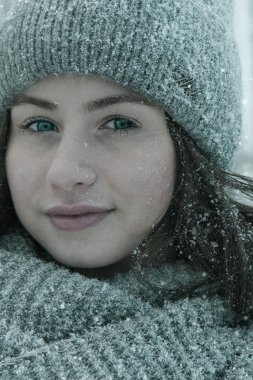 İlk kar. Karlı bir arka planda bir kızın kış fotoğraf çekimi.